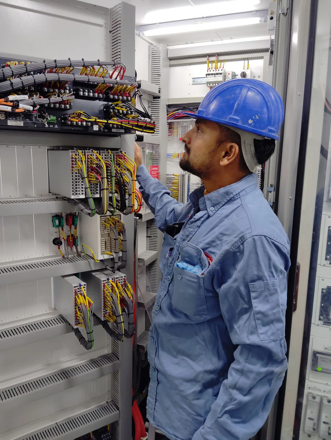 Eletricista trabalhando em quadro elétrico